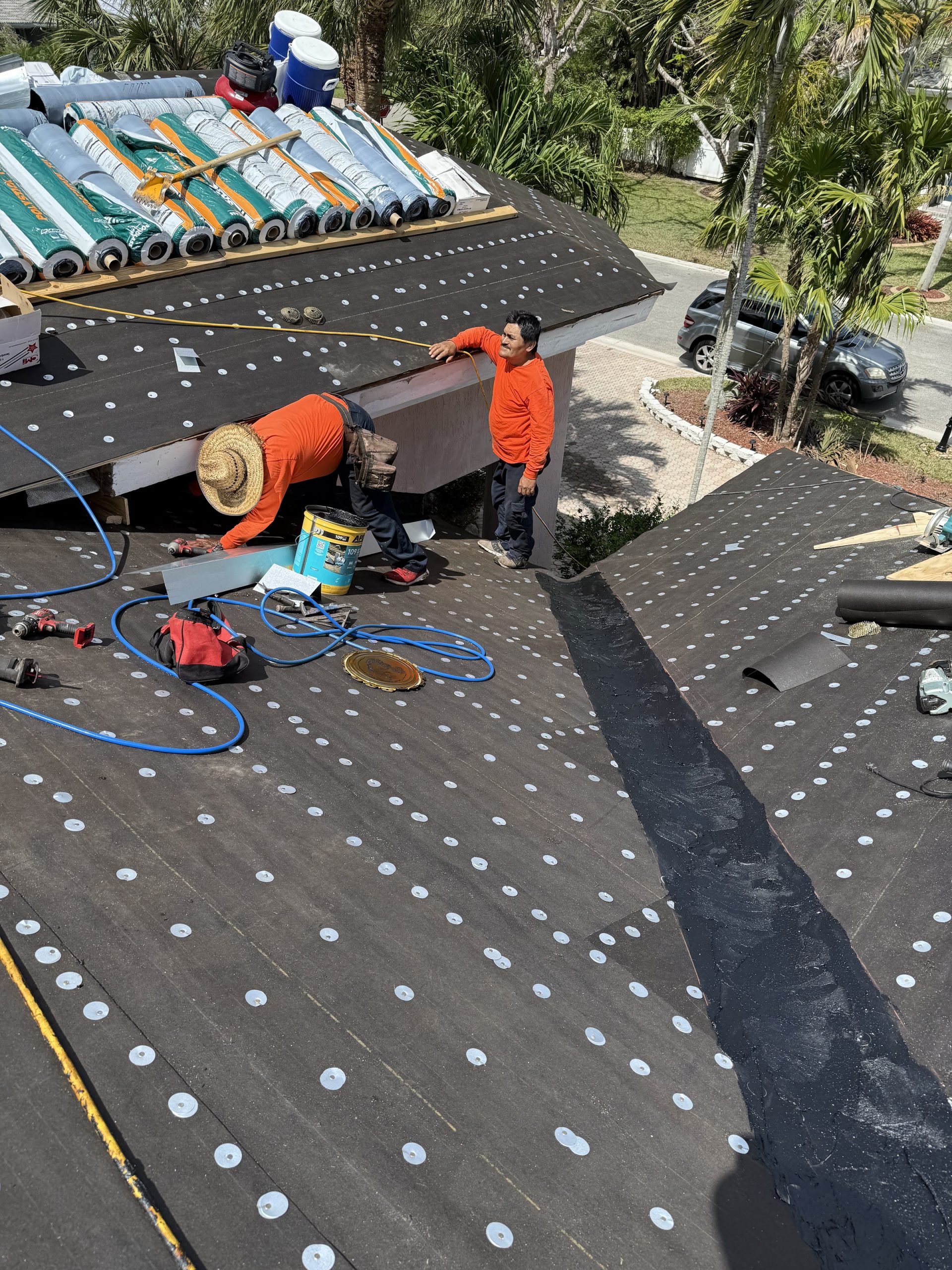 Roofing crew and tools on underlayment